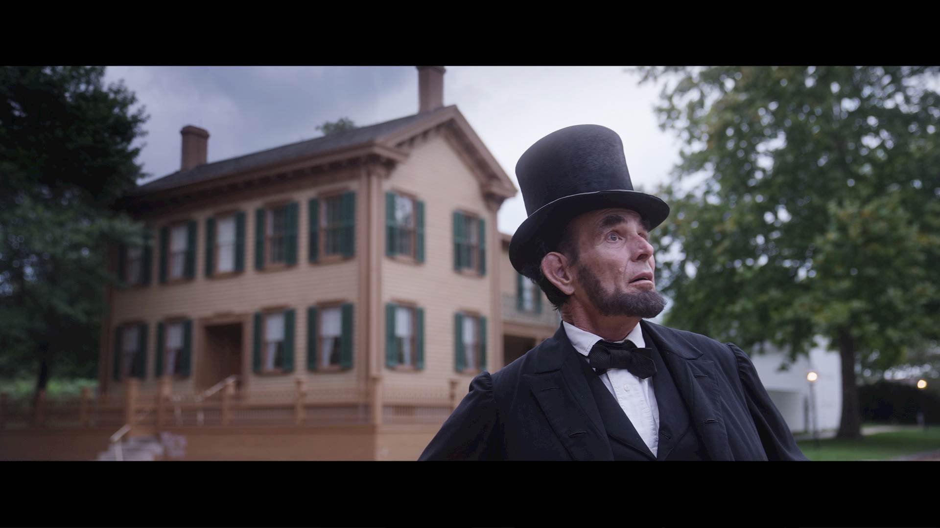 Lincoln looks off into the distance standing in front of Lincoln's home in Springfield, Illinois.